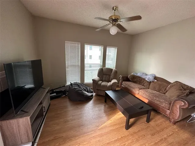 a living room with furniture ceiling fan and a window