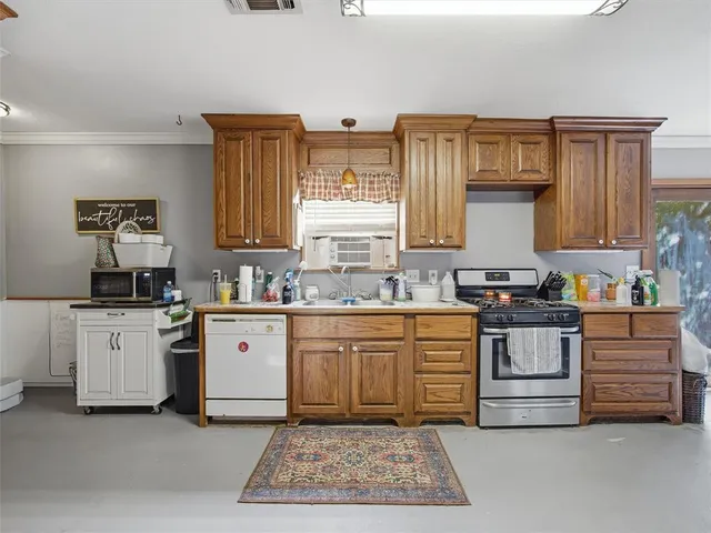 a kitchen with stainless steel appliances granite countertop a stove and white cabinets