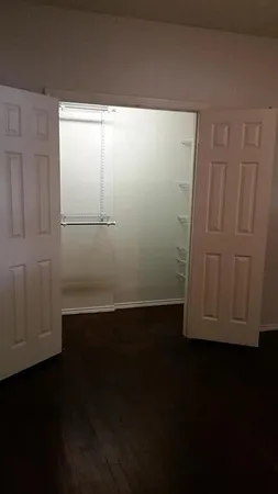 a view of walk in closet with wooden floor