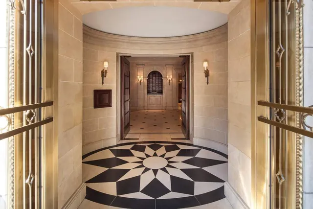 a view of a hallway with wooden floor and a chandelier