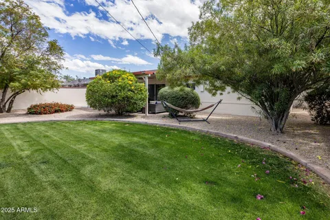 a view of a house with a big yard and potted plants