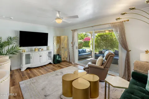 a living room with kitchen island stainless steel appliances and wooden floor