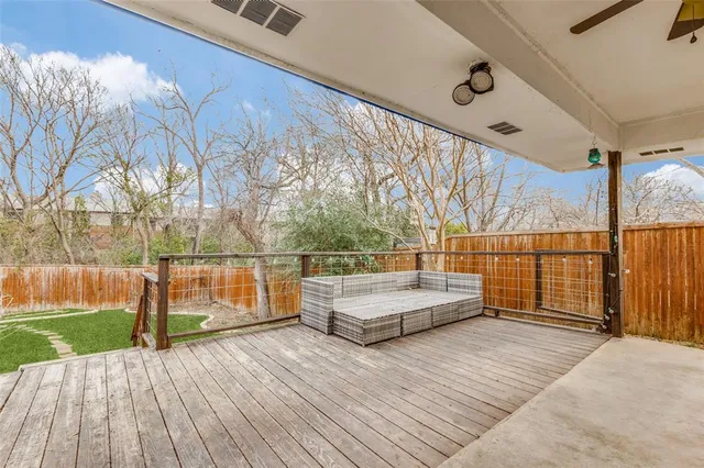 a view of house in front of a big yard with large trees
