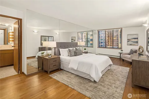 a large bedroom with a bed and wooden floor