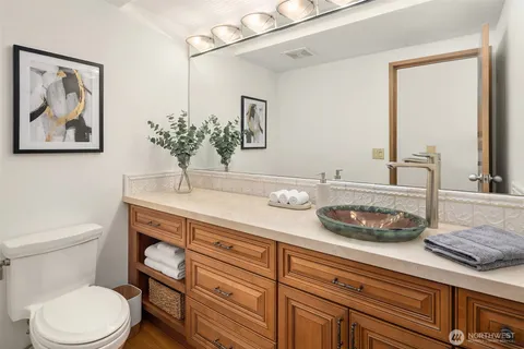 a bathroom with a granite countertop toilet sink and mirror