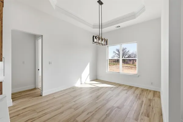 a view of a room with a window and wooden floor