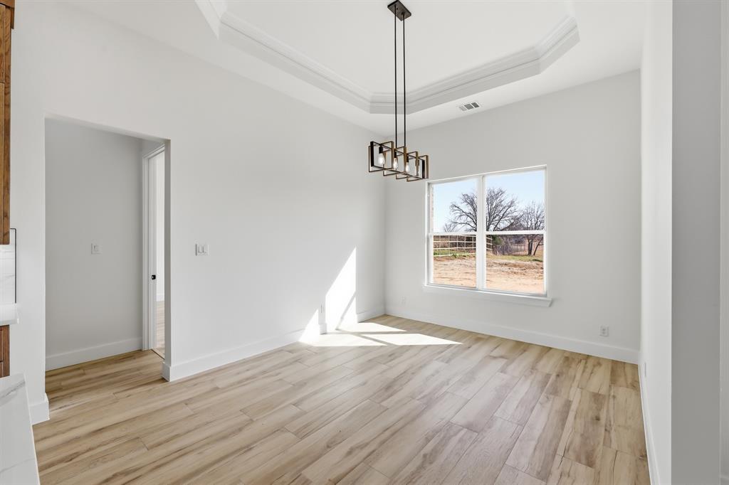 150 Briar Patch Azle, TX 76020 - Photo 26 of 40 a view of an empty room with wooden floor fridge and a window
