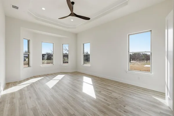 a view of a livingroom with wooden floor and a ceiling fan