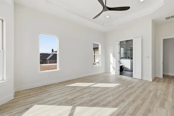 a spacious bathroom with a granite countertop sink a toilet a mirror and shower