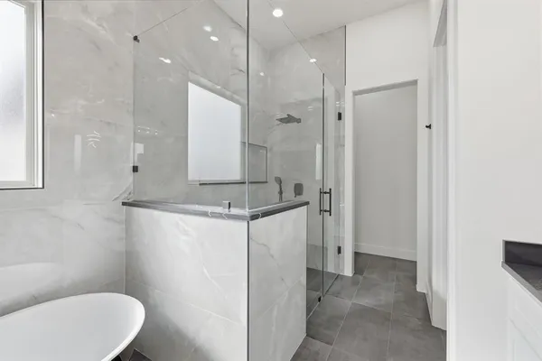 a spacious bathroom with a granite countertop sink a toilet a mirror and shower