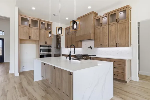 a kitchen with a sink dishwasher a stove and a refrigerator with wooden floor
