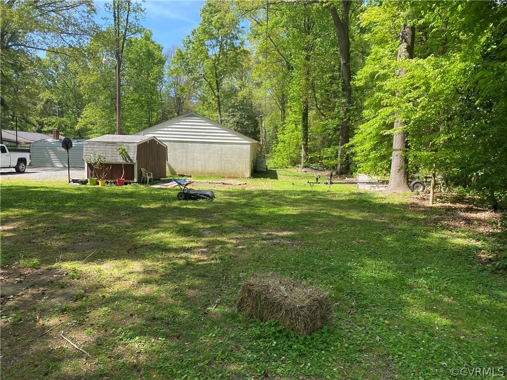 8250 Cadys Mill Road Hanover, VA 23069 - Photo 35 of 38 a backyard of a house with table and chairs plants and large tree
