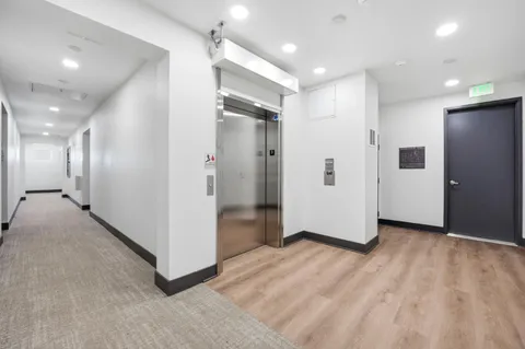 a view of a hallway with wooden floor