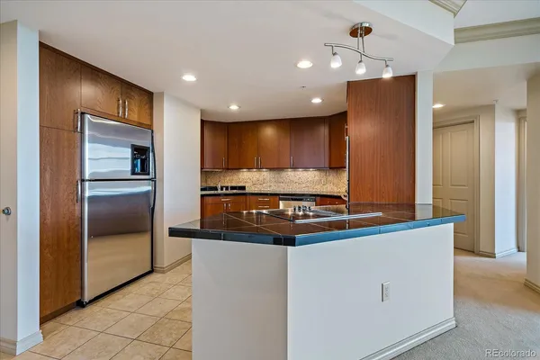 a kitchen with stainless steel appliances granite countertop a refrigerator and a stove