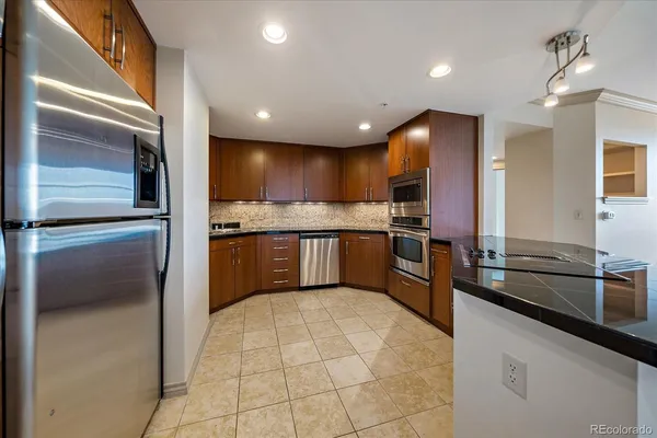 a kitchen with stainless steel appliances granite countertop a refrigerator and a sink