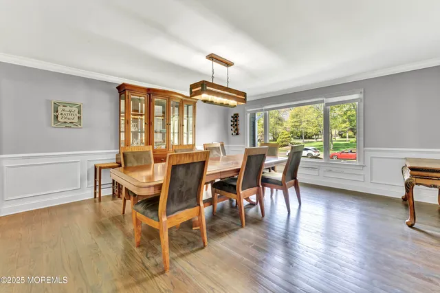 a dining room with furniture a chandelier and wooden floor