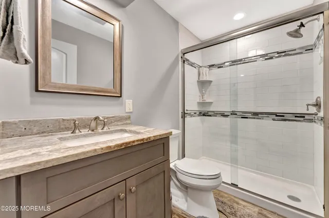 a bathroom with a granite countertop sink toilet and shower