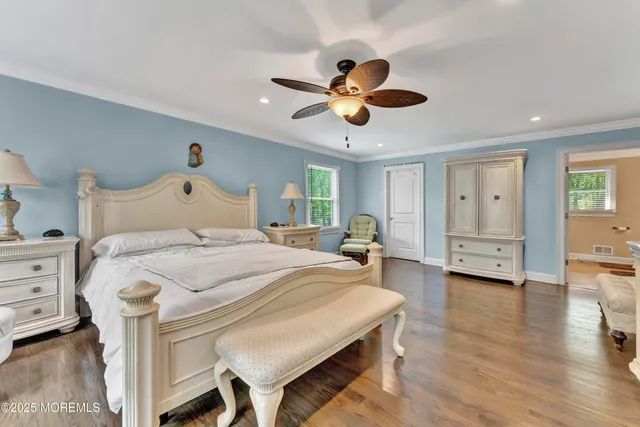 a bedroom with a bed chandelier and a window