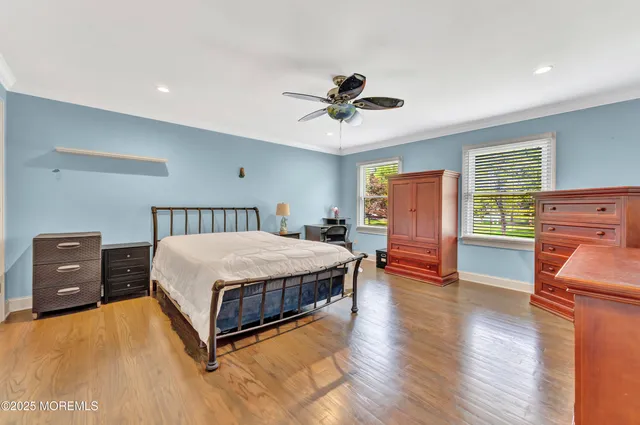 a spacious bedroom with a bed and wooden floor