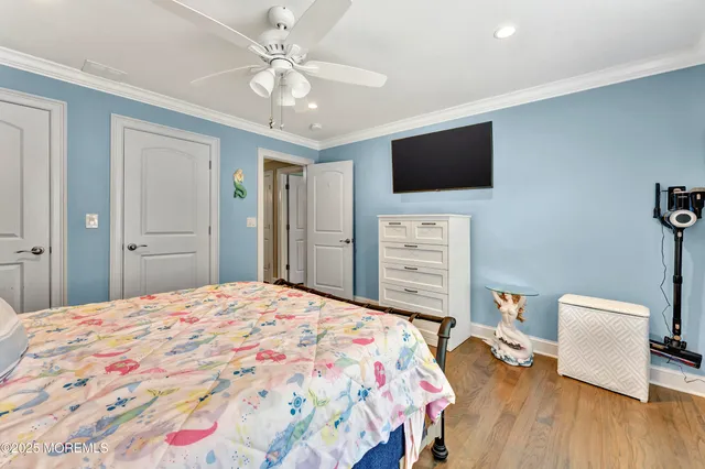 a bedroom with a bed a flat screen tv and a chandelier