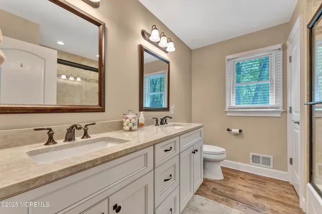 a bathroom with a granite countertop toilet sink and mirror