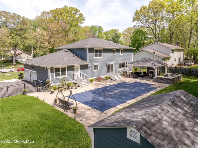 a view of a white house with a yard table and chairs under an umbrella