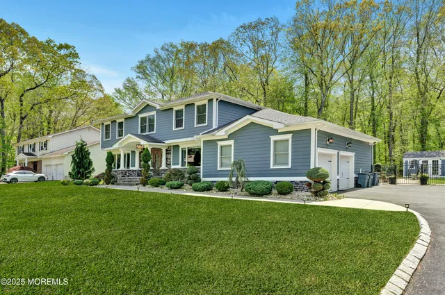 a front view of a house with a yard and trees
