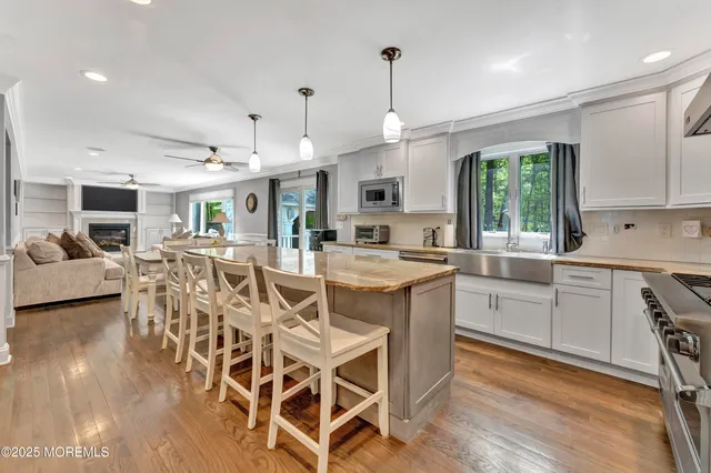 a kitchen with stainless steel appliances a dining table chairs stove and white cabinets