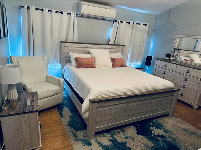 a bedroom with a bed and wooden floor