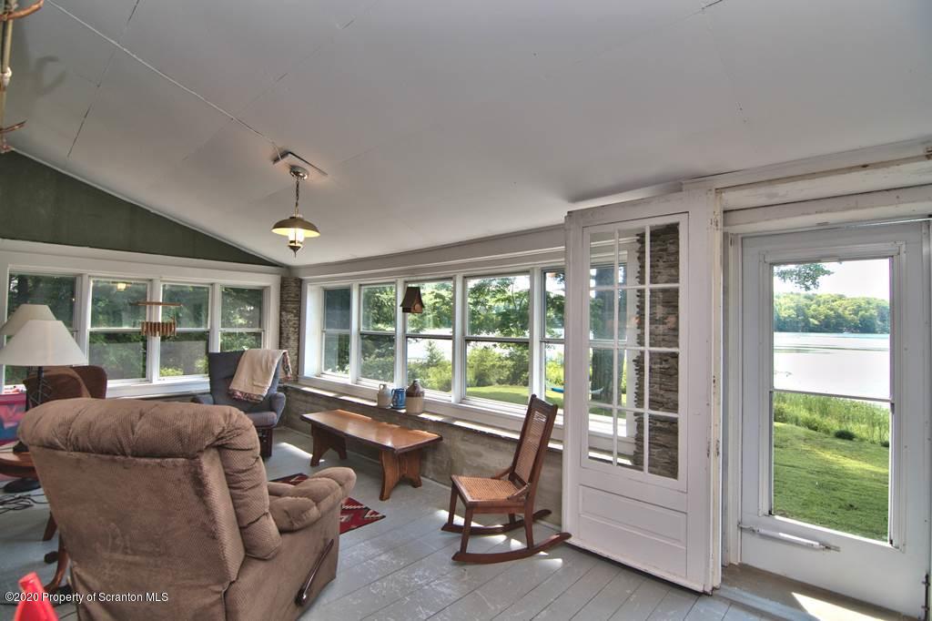292 Loomis Lk Road Hop Bottom, PA 18824 - Photo 13 of 76 a living room with furniture and floor to ceiling windows