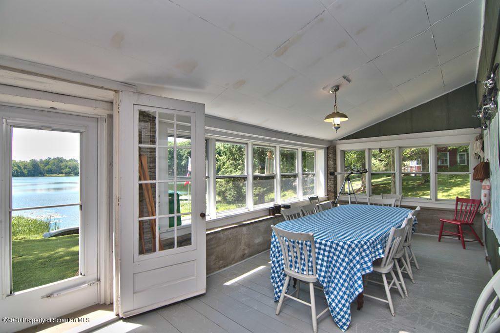 292 Loomis Lk Road Hop Bottom, PA 18824 - Photo 14 of 76 a dining room with furniture large windows and a chandelier