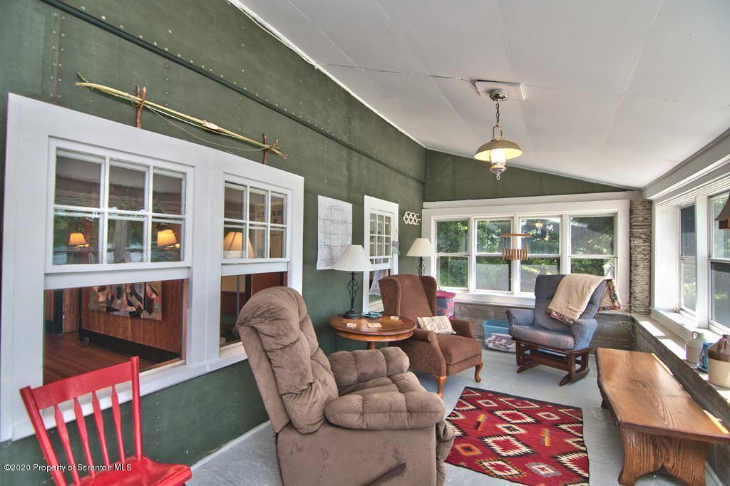 292 Loomis Lk Road Hop Bottom, PA 18824 - Photo 18 of 76 a living room with furniture and a floor to ceiling window