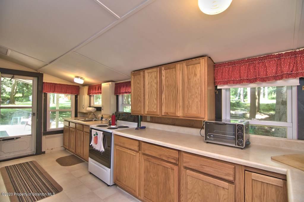 292 Loomis Lk Road Hop Bottom, PA 18824 - Photo 21 of 76 a kitchen with a sink stove and cabinets
