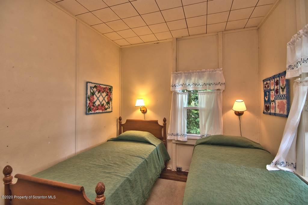 292 Loomis Lk Road Hop Bottom, PA 18824 - Photo 29 of 76 a bedroom with a bed and a chandelier