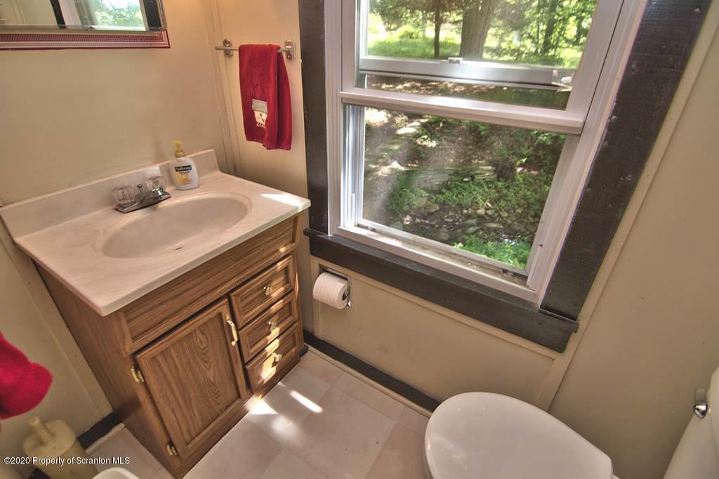292 Loomis Lk Road Hop Bottom, PA 18824 - Photo 34 of 76 a bathroom with a sink mirror vanity and toilet