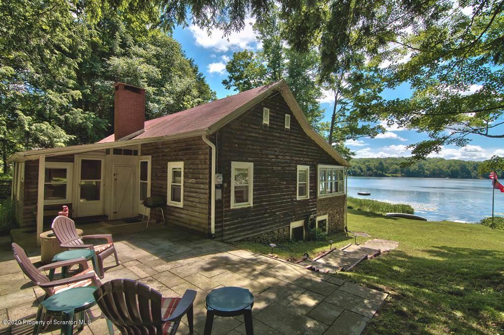 292 Loomis Lk Road Hop Bottom, PA 18824 - Photo 59 of 76 a backyard of a house with lake view and a potted plant