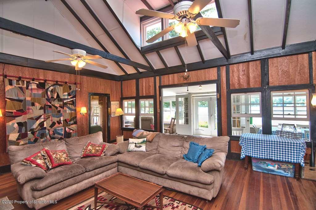 292 Loomis Lk Road Hop Bottom, PA 18824 - Photo 8 of 76 a living room with furniture and a floor to ceiling window