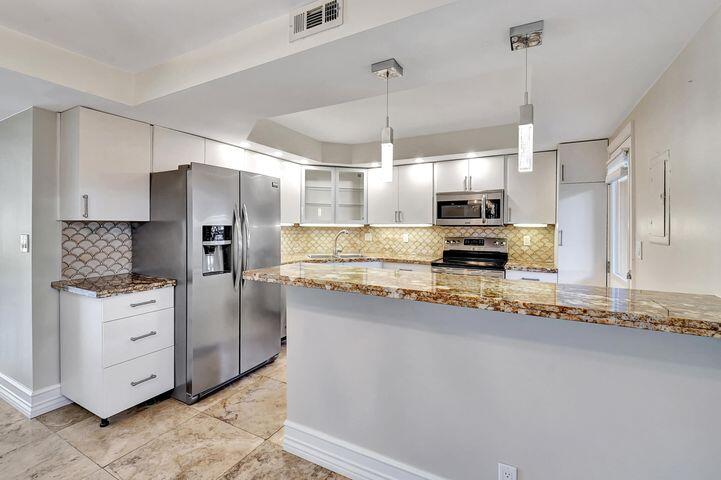 1 Harbourside Drive, Unit 4102 Delray Beach, FL 33483 - Photo 3 of 10 a kitchen with stainless steel appliances granite countertop a refrigerator a sink and a stove