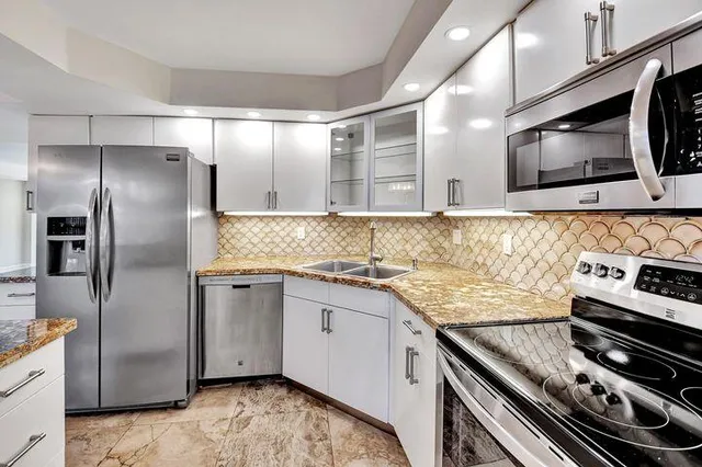 a kitchen with stainless steel appliances granite countertop a sink and a stove