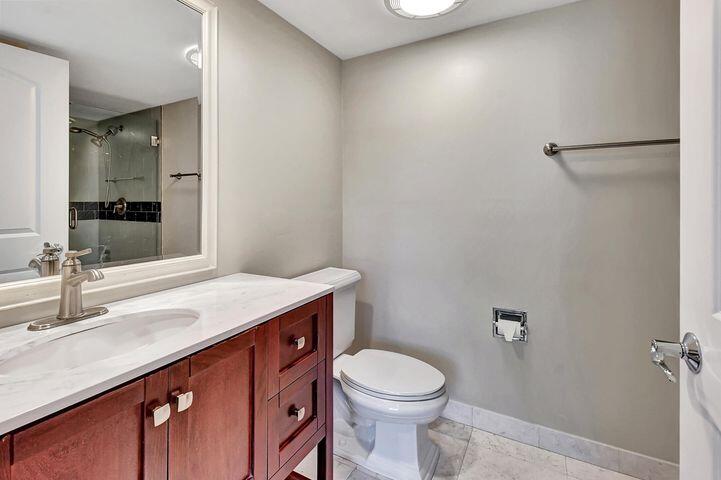 1 Harbourside Drive, Unit 4102 Delray Beach, FL 33483 - Photo 8 of 10 a bathroom with a sink a toilet a mirror and vanity