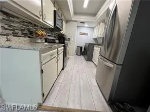 a kitchen with a sink a refrigerator freezer a stove top oven and a counter top space