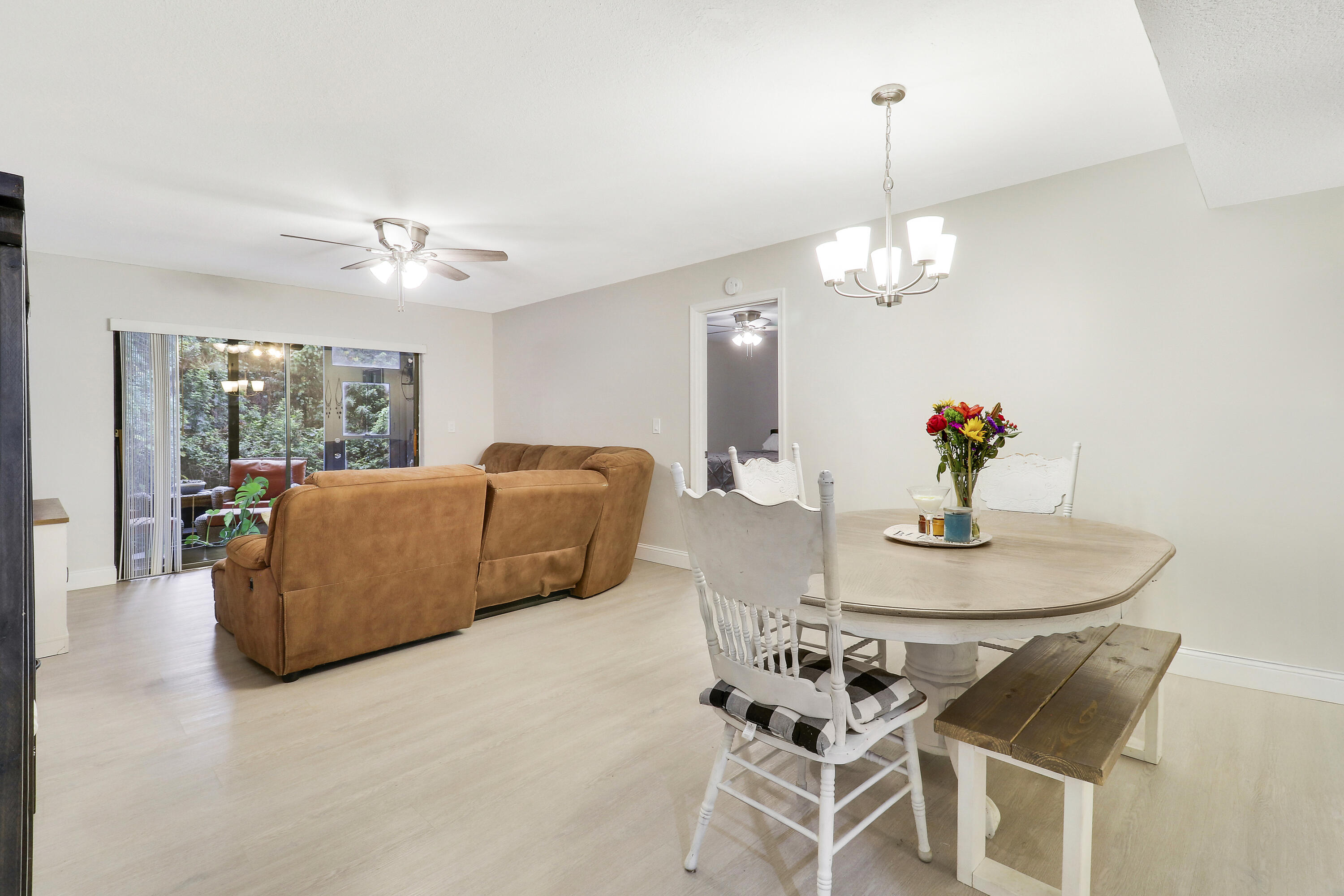 1200 Southeast Parkview Place, Unit F3 Stuart, FL 34994 - Photo 12 of 32 a living room with furniture a chandelier and a dining table