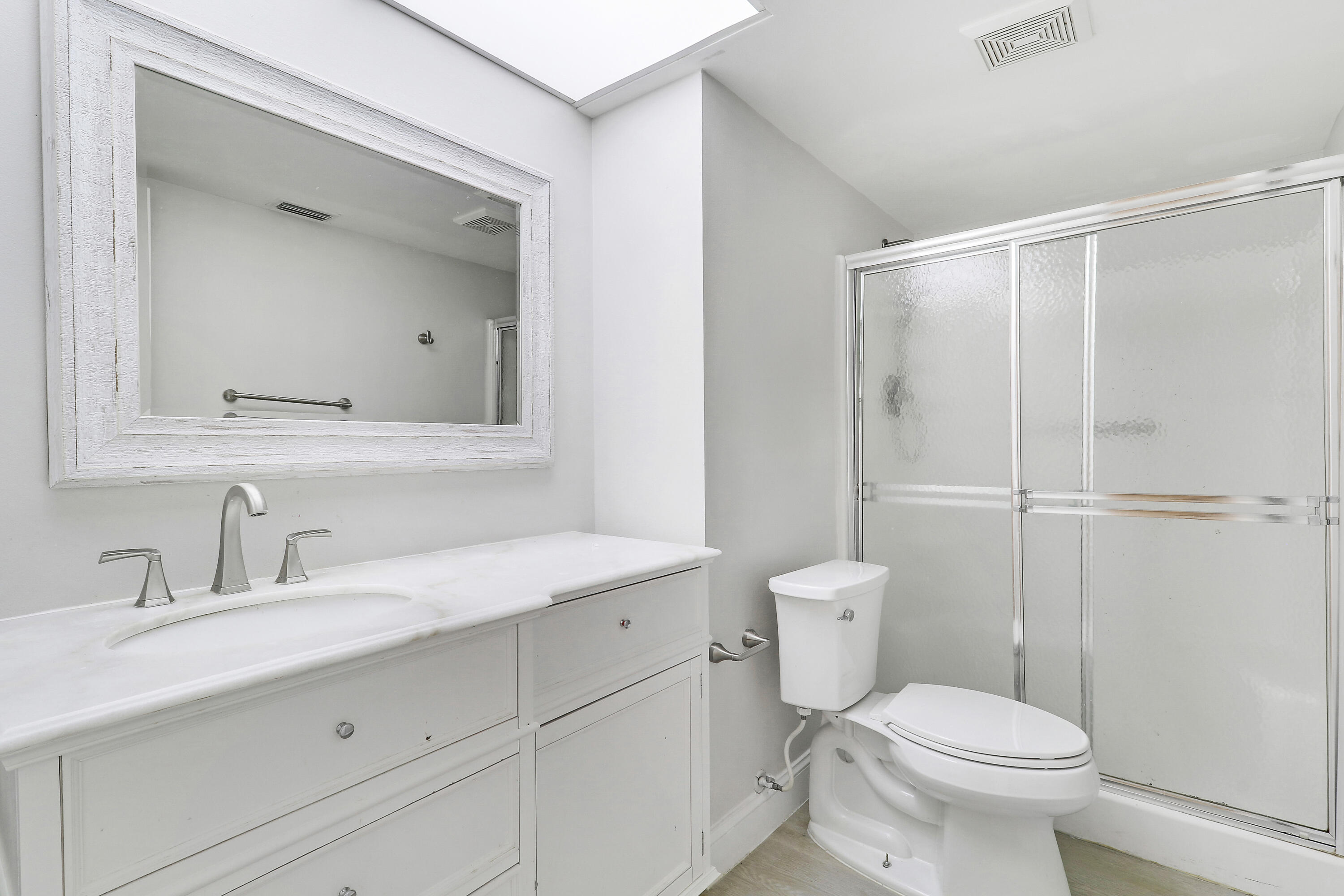 1200 Southeast Parkview Place, Unit F3 Stuart, FL 34994 - Photo 23 of 32 a bathroom with a toilet a sink a vanity and mirror