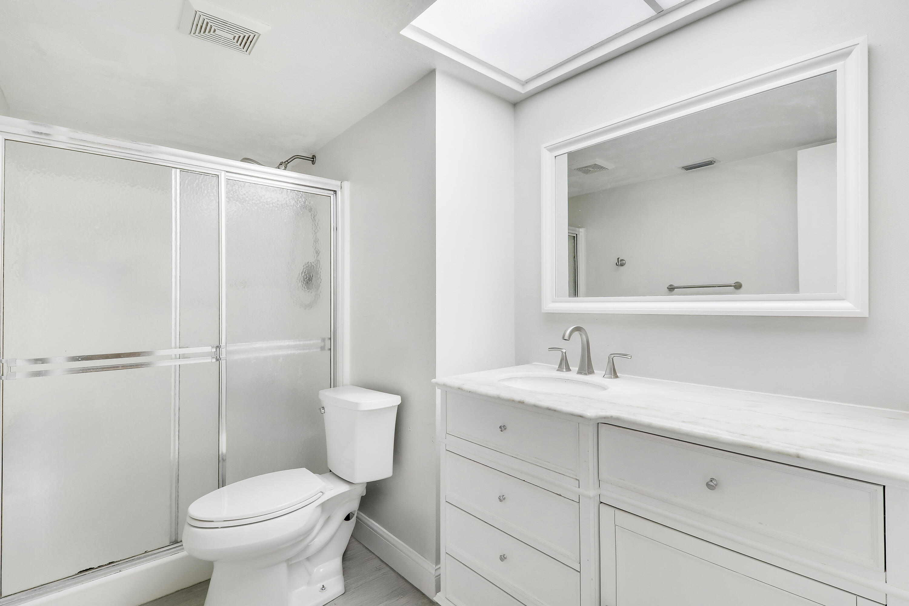 1200 Southeast Parkview Place, Unit F3 Stuart, FL 34994 - Photo 26 of 32 a bathroom with a toilet a sink a vanity and mirror