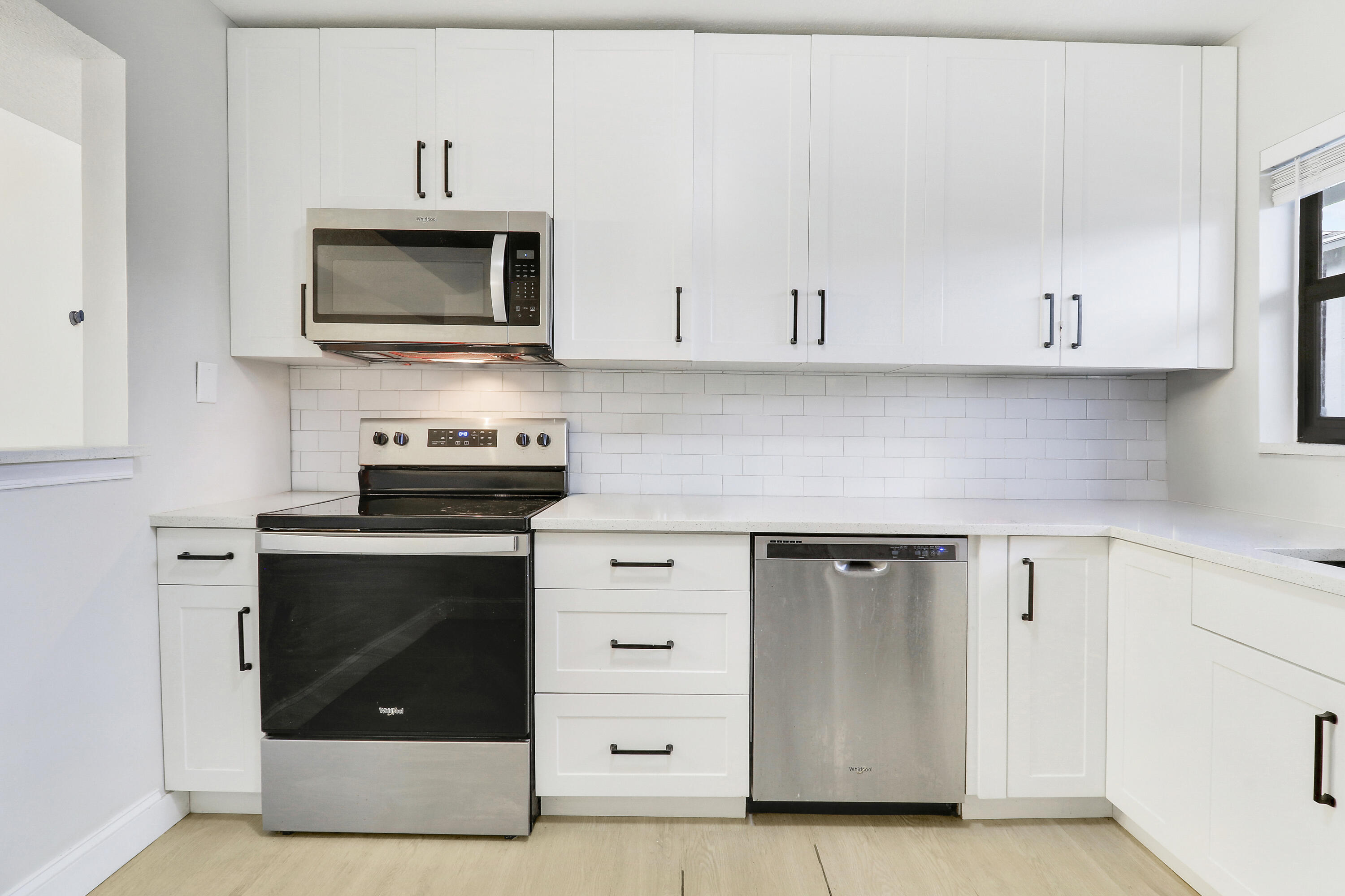1200 Southeast Parkview Place, Unit F3 Stuart, FL 34994 - Photo 5 of 32 a kitchen with white cabinets and stainless steel appliances