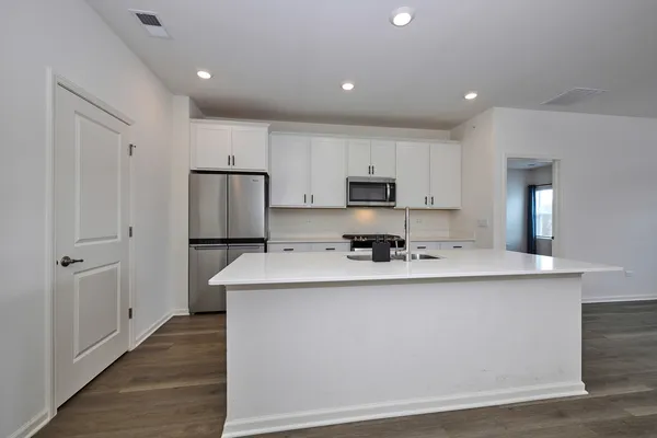 a kitchen with stainless steel appliances a sink stove and refrigerator