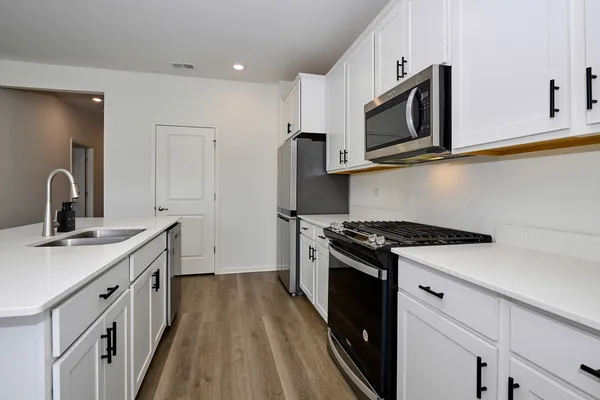 a kitchen with a sink stove and microwave