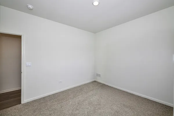 a spacious bedroom with a bed and a flat screen tv