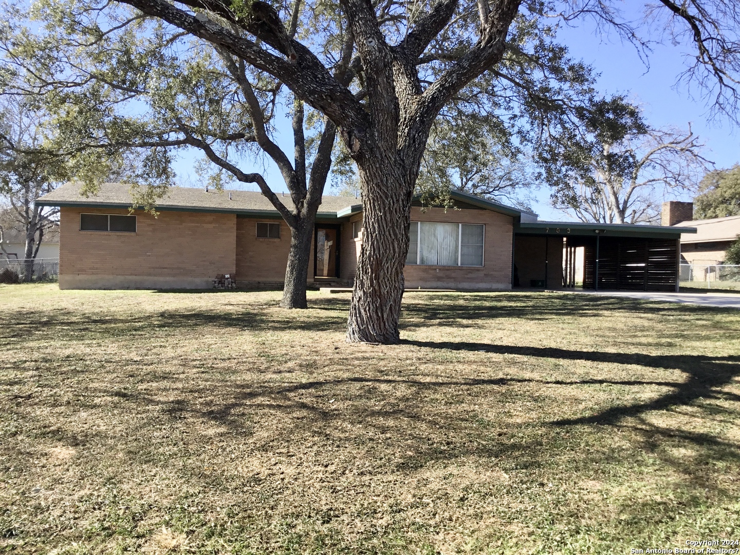 703 Atkins Avenue Devine, TX 78016 - Photo 1 of 1 a front view of a house with a yard