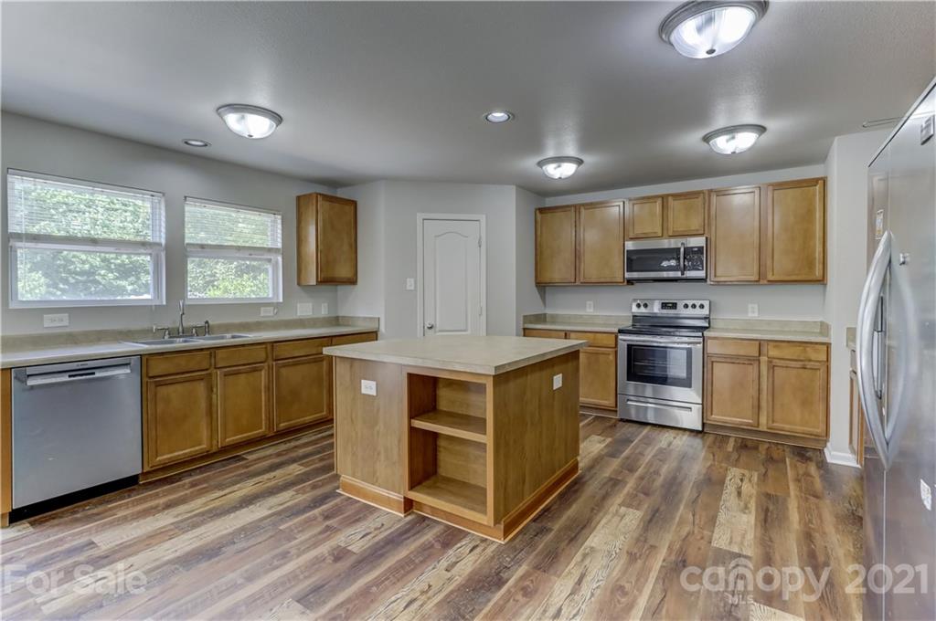2170 Durand Road, Unit 40 Fort Mill, SC 29715 - Photo 23 of 48 a kitchen with stainless steel appliances granite countertop a stove a sink dishwasher a refrigerator and a microwave oven with wooden floor